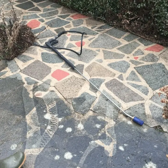 A shovel is laying on a stone walkway.