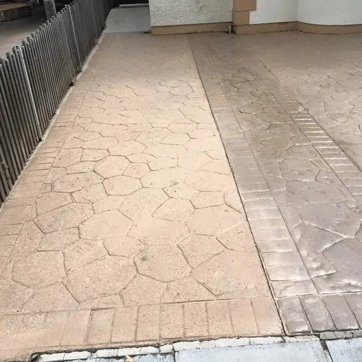 A sidewalk with a brick pattern on it, suitable for commercial cleaning.