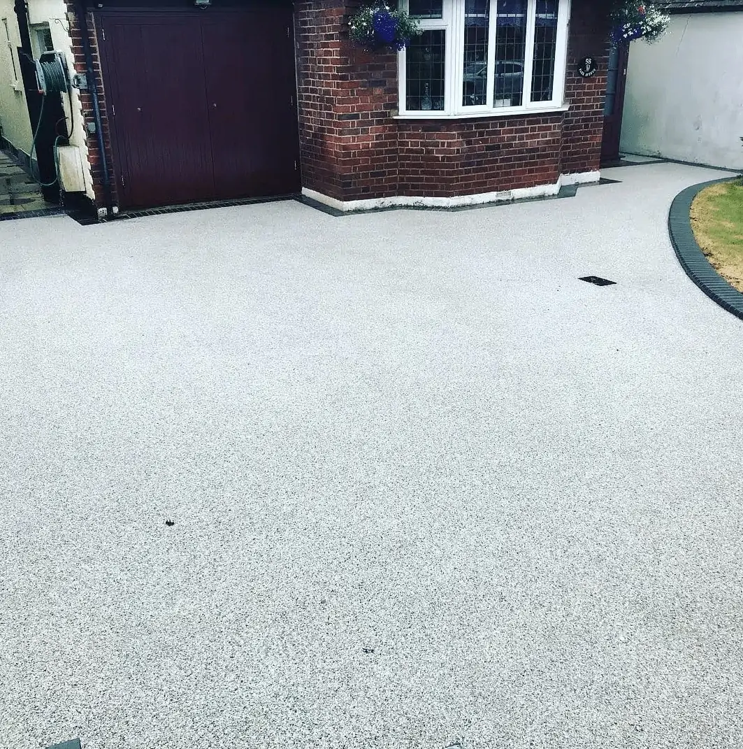 A house with a driveway and a garage that requires exterior cleaning.