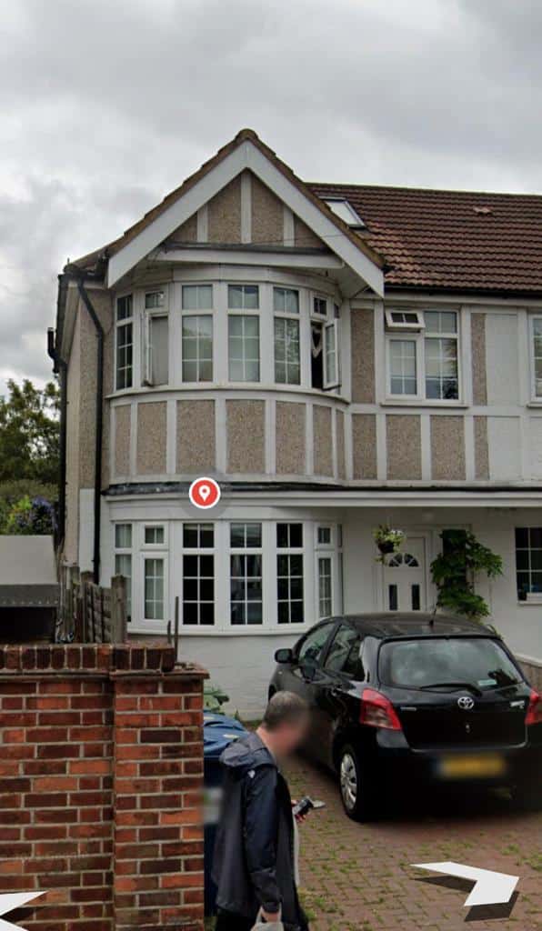 A house with a car parked in front of it, undergoing exterior cleaning for commercial purposes.
